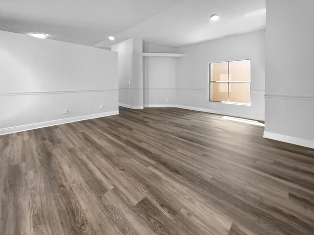 unfurnished room with dark wood-type flooring and baseboards