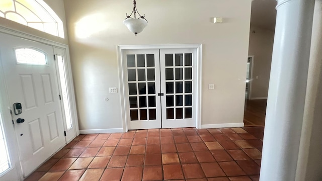 foyer featuring tile patterned floors, a high ceiling, and baseboards