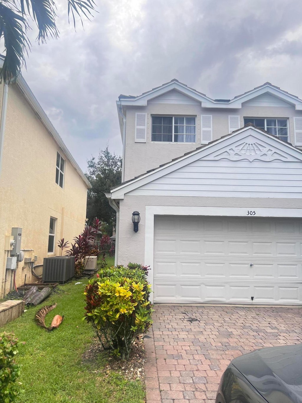 view of front facade featuring a garage, a front yard, and central air condition unit