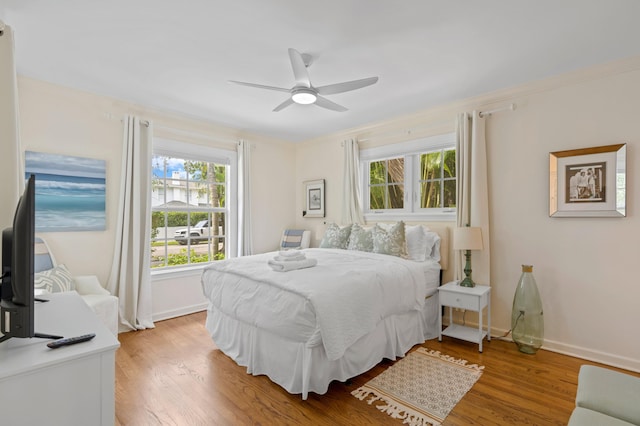 bedroom with light wood-type flooring, ornamental molding, and ceiling fan