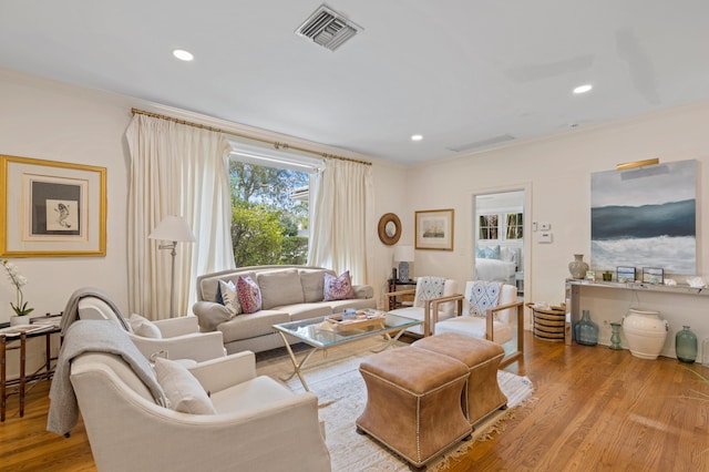 living room with light wood-type flooring and crown molding