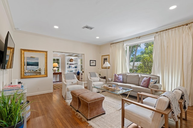 living room featuring wood-type flooring and ornamental molding