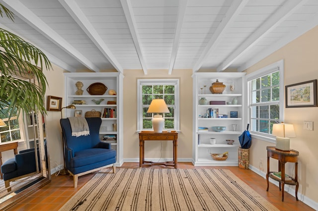 sitting room featuring beam ceiling, plenty of natural light, and tile patterned floors