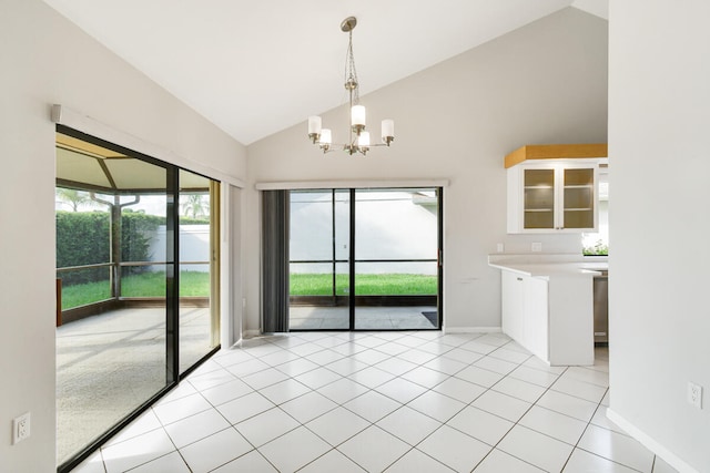 tiled empty room featuring lofted ceiling and a chandelier