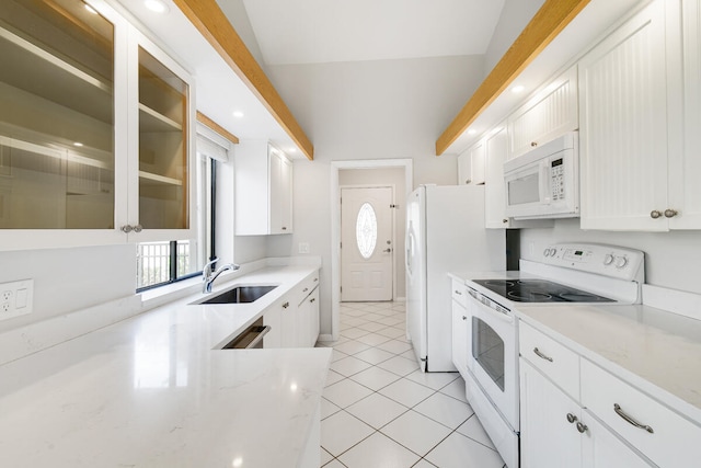 kitchen with vaulted ceiling, sink, white appliances, and white cabinets