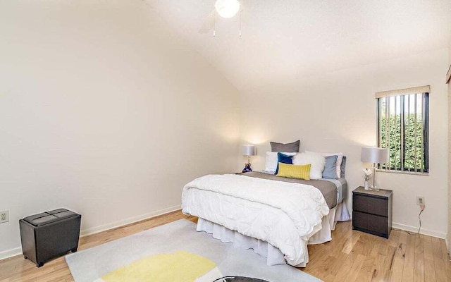 bedroom featuring ceiling fan, vaulted ceiling, and light hardwood / wood-style flooring