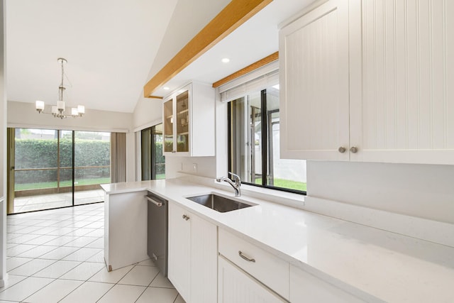 kitchen with lofted ceiling, plenty of natural light, a notable chandelier, and sink