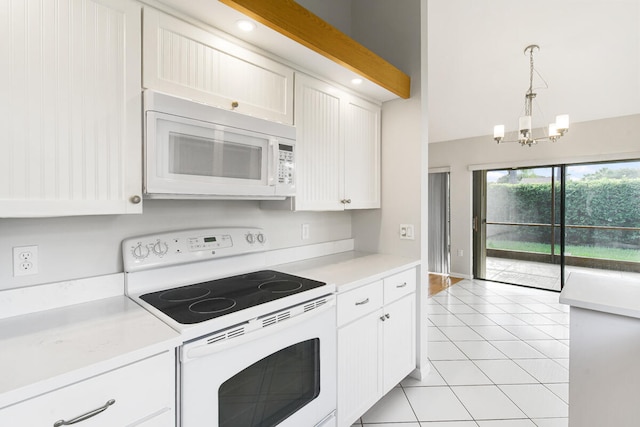 kitchen with white appliances, light tile patterned floors, hanging light fixtures, a chandelier, and white cabinets