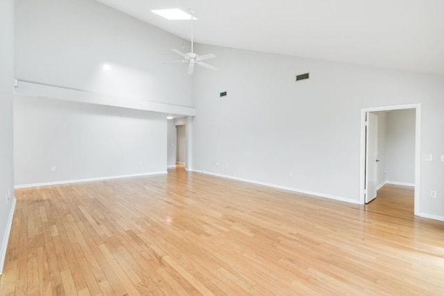 empty room with light wood-type flooring, ceiling fan, and high vaulted ceiling