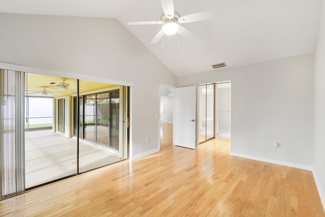 empty room with high vaulted ceiling, ceiling fan, and light hardwood / wood-style floors