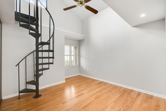 interior space featuring light hardwood / wood-style flooring, ceiling fan, and high vaulted ceiling