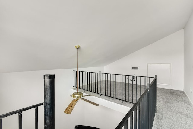 hallway with carpet flooring and vaulted ceiling