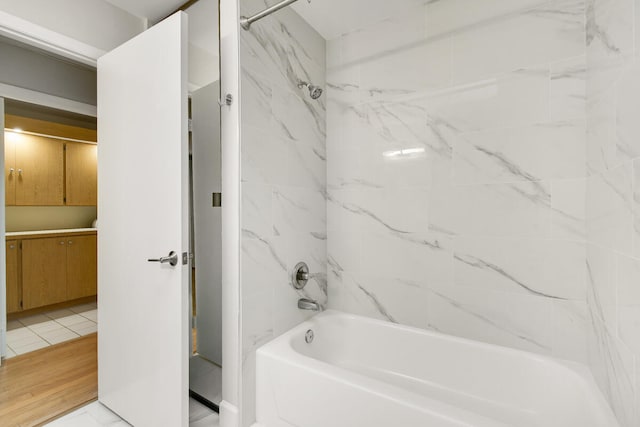 bathroom with tiled shower / bath and wood-type flooring