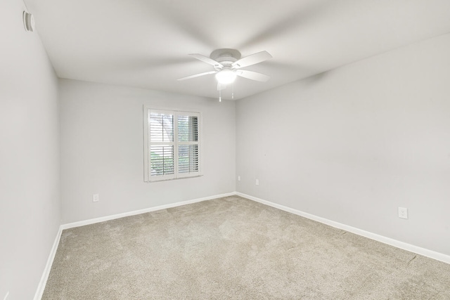 carpeted spare room featuring ceiling fan