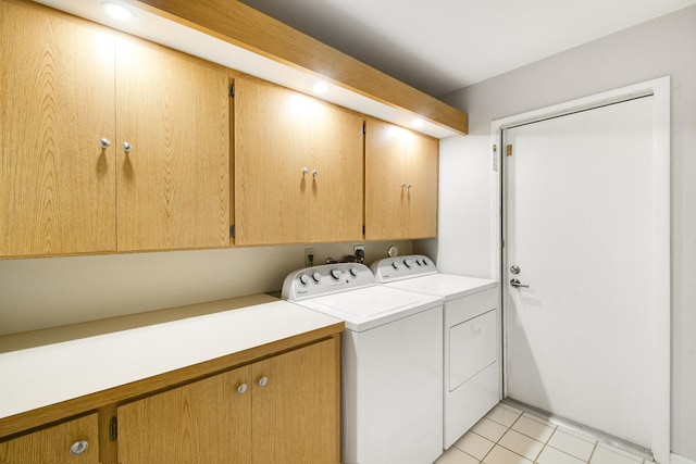 laundry room featuring light tile patterned floors, cabinets, and washer and dryer