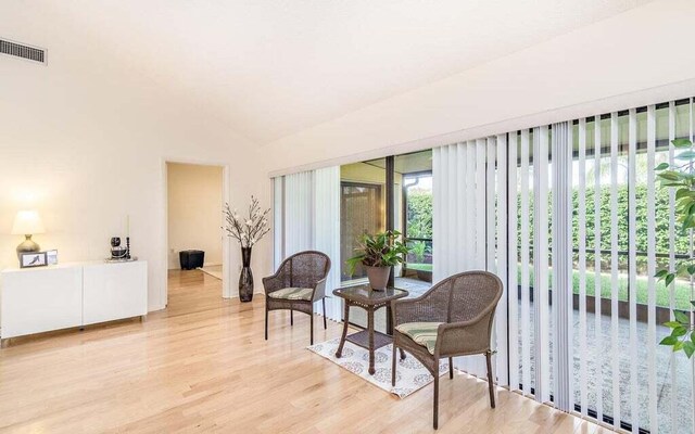 sitting room featuring lofted ceiling and light wood-type flooring