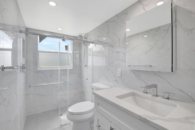 bathroom featuring vanity, toilet, tile walls, and a shower with shower door