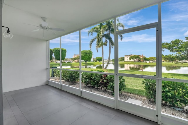 unfurnished sunroom featuring a water view, ceiling fan, and a wealth of natural light