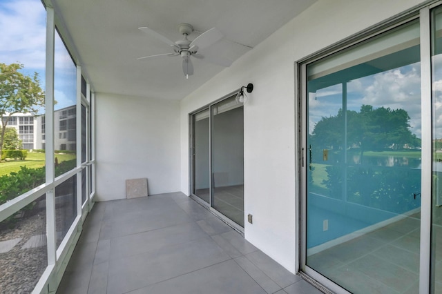 unfurnished sunroom featuring a water view and ceiling fan