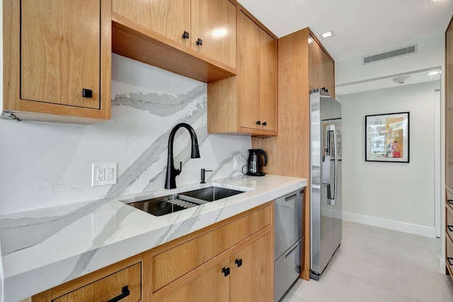 kitchen featuring light stone countertops, sink, and stainless steel appliances