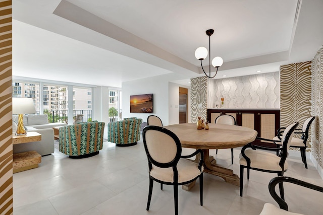 dining space featuring a raised ceiling and an inviting chandelier