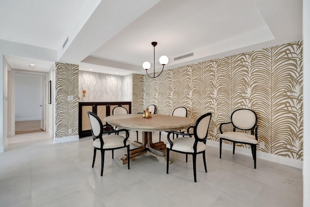 dining area featuring a tray ceiling and a chandelier