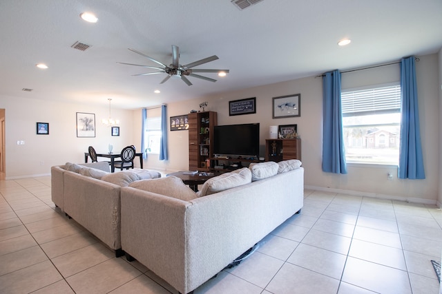 living room featuring light tile patterned floors and ceiling fan with notable chandelier