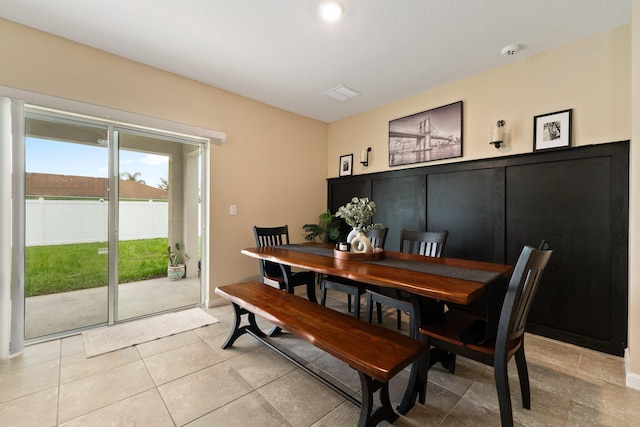 dining space with a water view and tile patterned floors