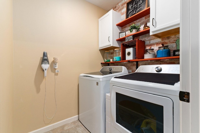 laundry area with washing machine and clothes dryer and cabinets