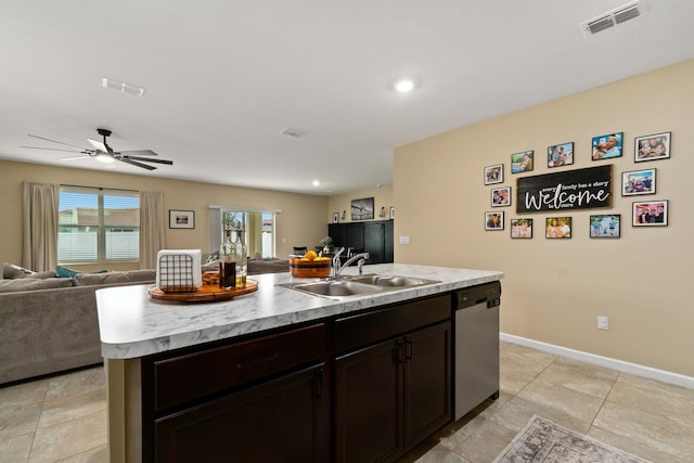 kitchen featuring stainless steel dishwasher, dark brown cabinetry, ceiling fan, sink, and a center island with sink