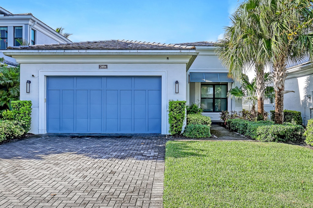 view of front of property with a front yard and a garage