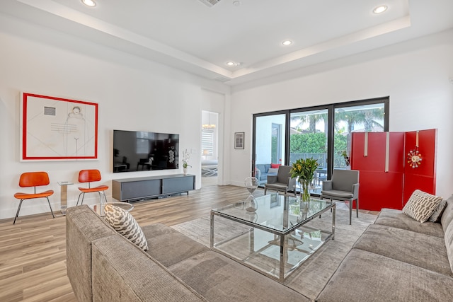 living room with a tray ceiling and hardwood / wood-style floors