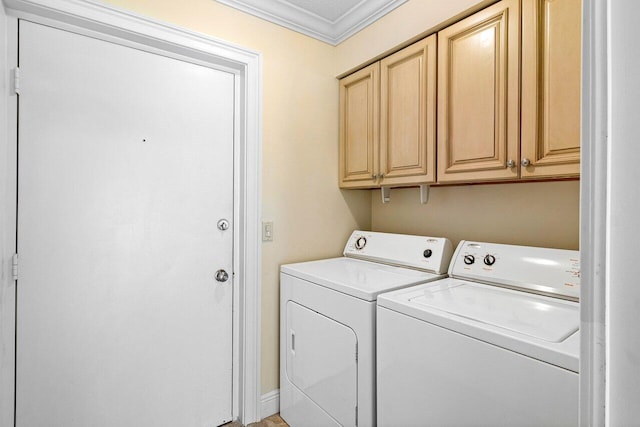 laundry room featuring cabinets, ornamental molding, and washing machine and clothes dryer