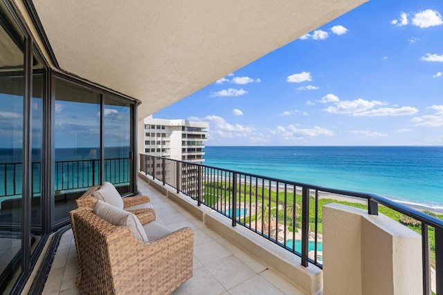 balcony featuring a water view and a view of the beach