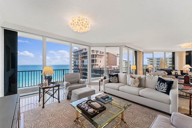 living room with plenty of natural light, a water view, and a wall of windows