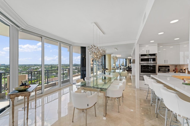 dining space with ornamental molding, plenty of natural light, a wall of windows, and an inviting chandelier