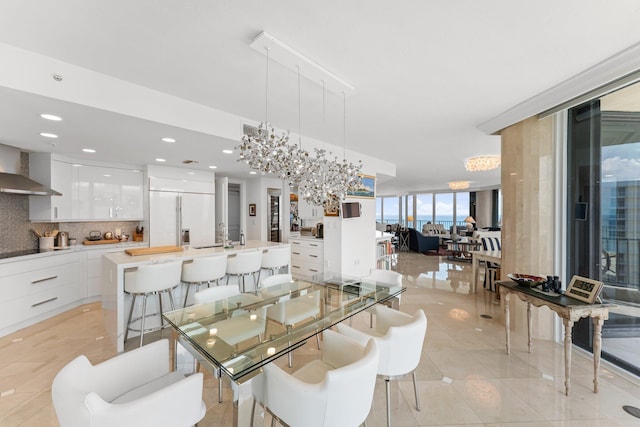 dining room with sink, light tile patterned floors, expansive windows, and an inviting chandelier