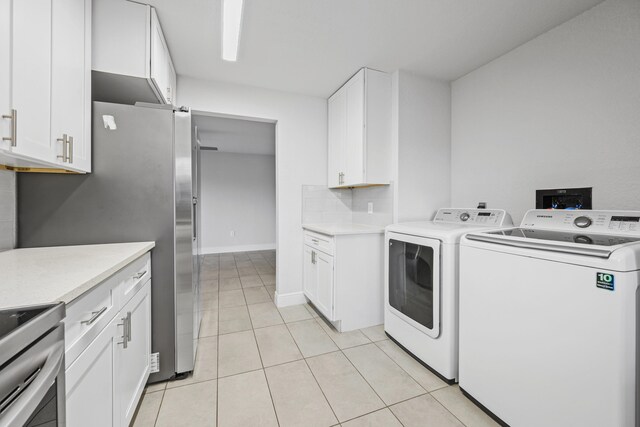 laundry room with independent washer and dryer and light tile patterned floors