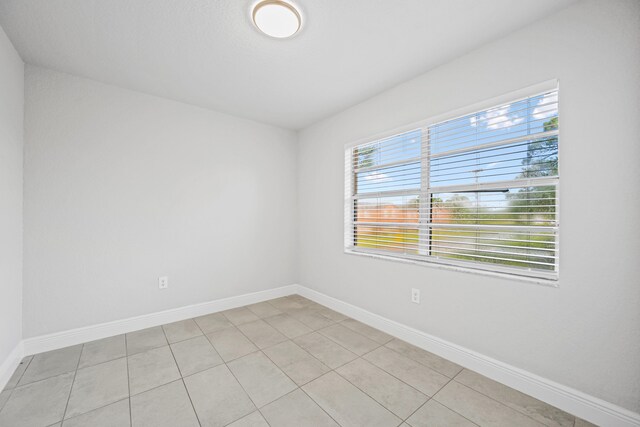 spare room featuring light tile patterned flooring