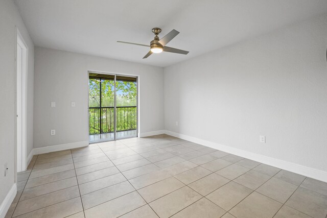 tiled spare room featuring ceiling fan