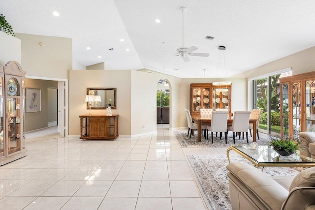 living room featuring ceiling fan, a textured ceiling, light tile patterned floors, and a healthy amount of sunlight