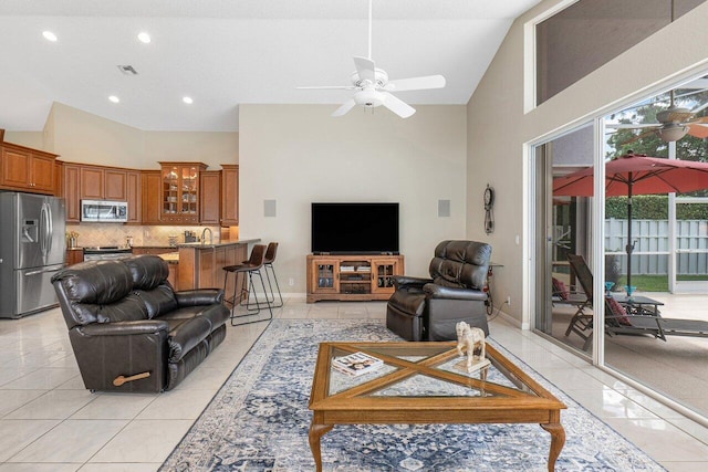 tiled living room featuring a towering ceiling and ceiling fan