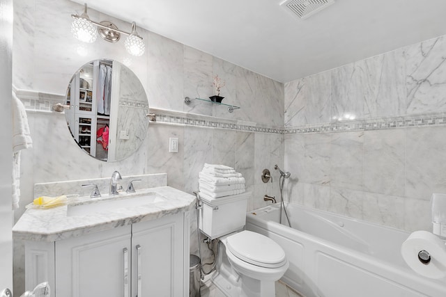 bathroom featuring a bathing tub, vanity, tile walls, and toilet