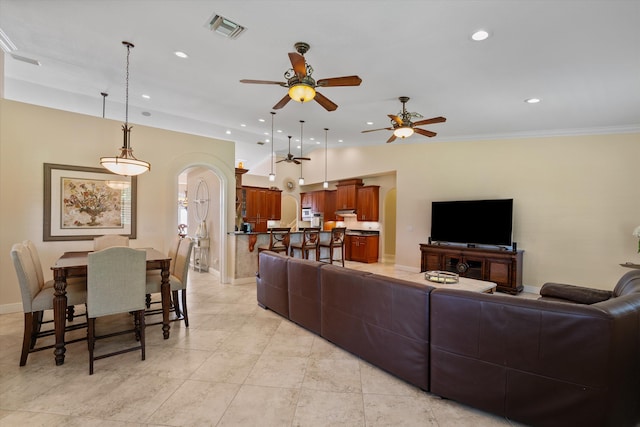 living room featuring ceiling fan, light tile patterned floors, and crown molding