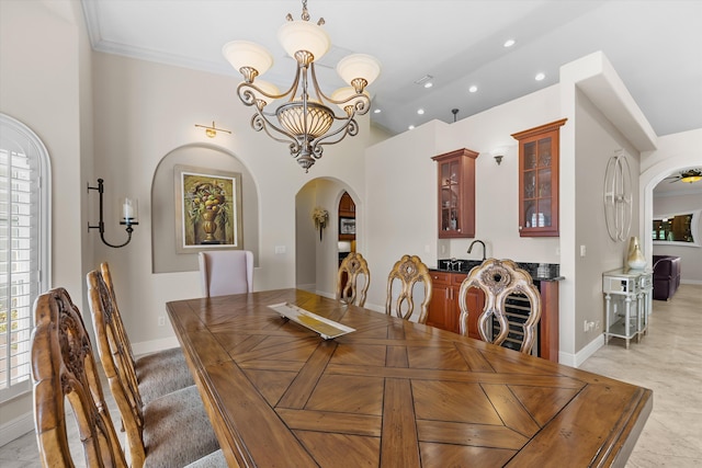 dining room with a healthy amount of sunlight, ornamental molding, sink, and a chandelier