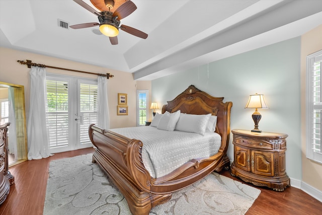 bedroom featuring ceiling fan, hardwood / wood-style flooring, a tray ceiling, and access to exterior