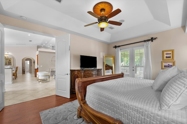 bedroom with wood-type flooring, ceiling fan, access to exterior, and french doors