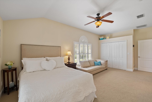 bedroom with ceiling fan, light colored carpet, a closet, and lofted ceiling