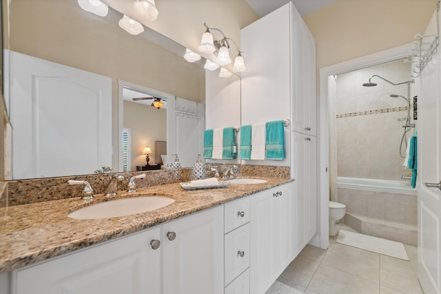 full bathroom featuring tiled shower / bath, vanity, ceiling fan, toilet, and tile patterned floors