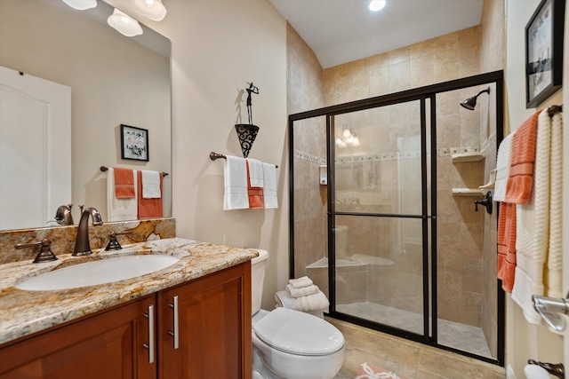 bathroom featuring vanity, toilet, a shower with door, and tile patterned floors